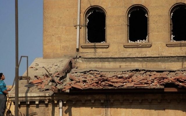 Un Egyptien sur la scène d'une explosion qui a ciblé l'église orthodoxe copte Saint Pierre et  Saint Paul du Caire et a fait 26 morts, le 11 décembre 2016. (Crédit :  Suhail Saleh/AFP)