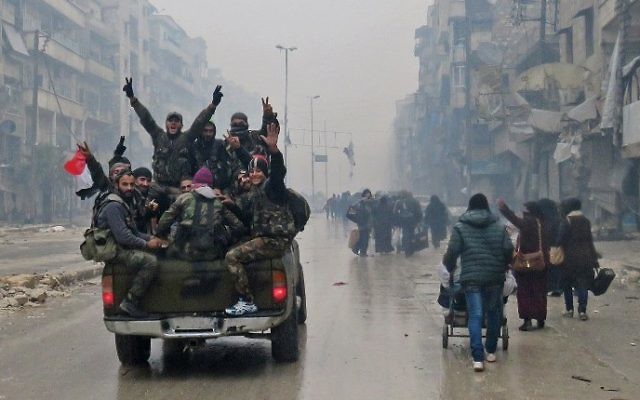 Des combattants pro-régime syrien et des habitants fuyant les violences dans le quartier Bustan al-Qasr d'Alep, le 13 décembre 2016. (Crédit : AFP/Stringer) Des combattants pro-régime syrien et des habitants fuyant les violences dans le quartier Bustan al-Qasr d'Alep, le 13 décembre 2016. (Crédit : AFP/Stringer)