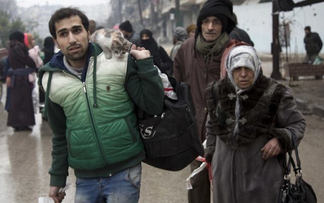 Des Syriens quittent un quartier d'Alep tenu par les rebelles pour la partie sous contrôle gouvernementale pendant une opération des forces du gouvernement syrien pour reprendre la ville assiégée, le 13 décembre 2016. (Crédit : Karam al-Masri/AFP)
