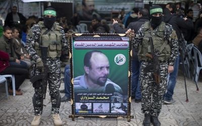 Des membres des Brigades Ezzedine al-Qassam Brigades, la branche armée du Hamas, avec un portrait de Mohammed al-Zoari, qui a été tué en Tunisie, pendant une cérémonie en son honneur dans la ville de Gaza, le 18 décembre 2016. (Crédit : Mahmud Hams/AFP)