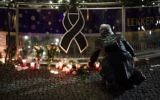 Une femme allume une bougie sous un arbre de Noël à proximité de la porte de Brandenburg à Berlin le 20 décembre 2016, un jour après qu'un camion-bélier ait fondé sur un marché de Noël. (Crédit : Clemens Bilan/AFP)