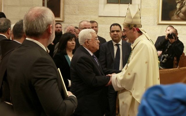Le président de l'Autorité palestinienne Mahmoud Abbas, au centre à gauche, avec l'archevêque Pierbattista Pizzaballa, l'administrateur apostolique du Patriarche latin de Jérusalem, pendant la messe de Noël de l'église Sainte-Catherine de l'église de la Nativité, à Bethléem, en Cisjordanie, le 25 décembre 2016. (Crédit : Musa al-Shaer/Pool/AFP)