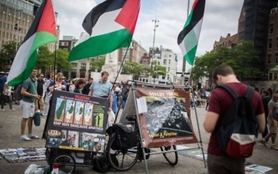 Des touristes israéliens devant un stand du BDS avec des photos et des drapeaux palestiniens, appelant à la "Palestine libre", à  sur la place de Dam, au centre d'Amsterdam, en Hollande, le 24 juin 2016. Illustration. (Crédit : Hadas Parush/Flash90)