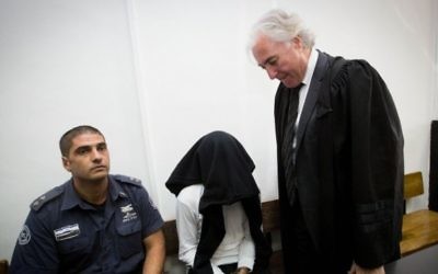 Ben Deri (centre), accusé d'avoir tué un jeune Palestinien de 20 ans en utilisant des balles réelles durant des affrontements à  Betunia en Cisjordanie, avec son avocat  Zion Amir (à droite), au cours de son audience devant le Tribunal de district de Jérusalem le 7 décembre 2014 (Crédit : Miriam Alster/Flash90)