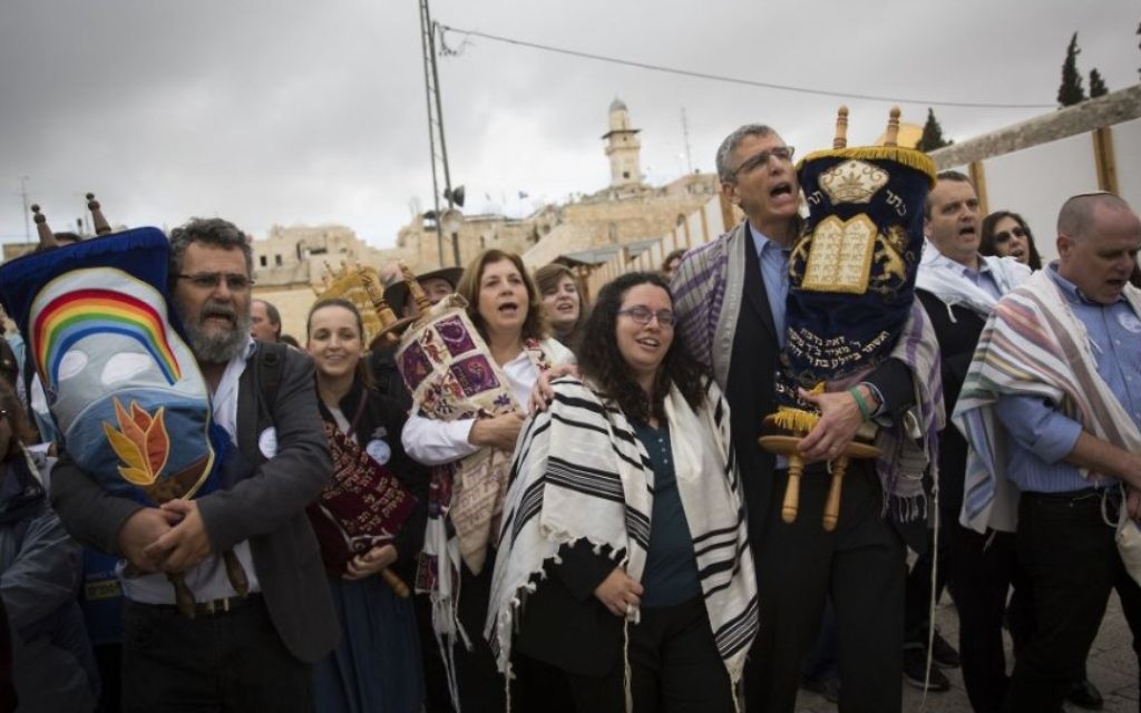 Des rabbins conservative et réformés américains et des membres des Femmes du Mur brandissent des rouleaux de la Torah durant une manifestation contre l'absence de construction d'un nouvel espace de prière, au mur Occidental, dans la Vieille Ville de Jérusalem, le 2 novembre 2016. (Crédit : Hadas Parush/Flash90)