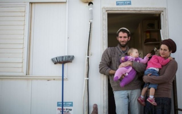 Neria, à gauche, Tova, à droite, et leurs deux enfants devant l'entrée de leur habitation dans l'avant-poste d'Amona, en Cisjordanie, le 16 décembre 2016. (Crédit : Hadas Parush/Flash90)