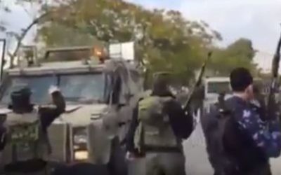 Des policiers palestiniens, armés de fusils d'assaut, empêchent des véhicules militaires israéliens d'entrer dans Jénine. (Crédit : capture d'écran YouTube)