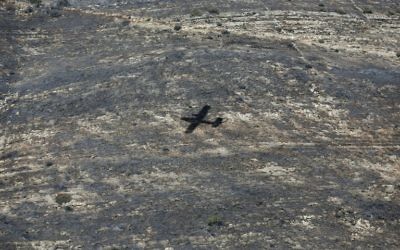 L'ombre d'un bombardier d'eau turc sur le village de Nataf près de Jérusalem, pour aider à maitriser les incendies le 26 novembre 2016. (Crédit : AFP PHOTO / AHMAD GHARABLI)