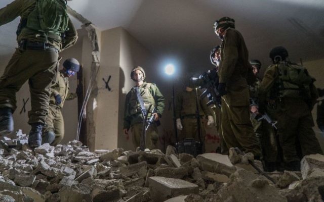 Des soldats israéliens détruisent la maison de Mesbah Abu Sabih, un Palestinien qui a tué deux Israéliens pendant une attaque à main armée à Jérusalem en octobre 2016, dans le quartier Kafr Aqab de Jérusalem Est, le 22 décembre 2016. (Crédit : unité des portes-paroles de l'armée israélienne)
