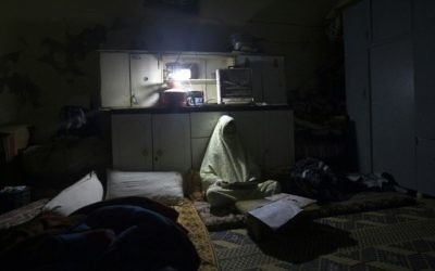 Une fillette palestinienne fait ses devoirs pendant une coupure de courant au camp de réfugiés d'Al-Shati, à Gaza ville, le 4 janvier 2017. (Crédit : Mahmud Hams/AFP)