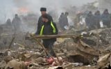 Les personnels de secours sur le site où un avion s'est écrasé dans le village de Datcha-Souou, près de Bishkek, au Kirghizstan, le 16 janvier 2017. (Crédit : Vyacheslav Oseledko/AFP)
