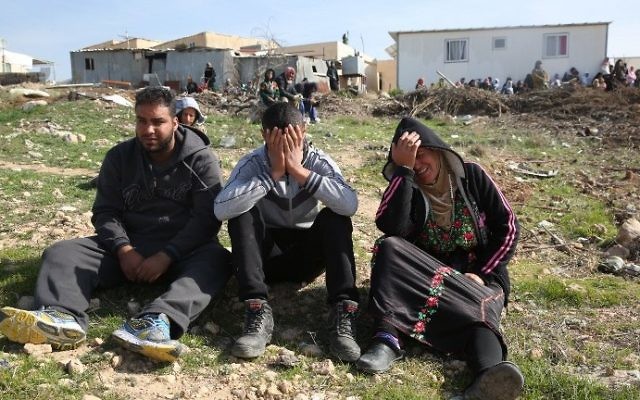 Des Bédouins en larmes après des démolitions de maisons dans le village bédouin non reconnu d'Umm al-Hiran, dans le désert du Néguev, le 18 janvier 2017. (Crédit : Menahem Kahana/AFP)