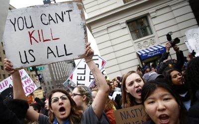 Des manifestantes entourent un char de la parade en provoquant des partisans de Trump lors de la Marche des femmes du 21 janvier 2017 à Washington (Crédit : Joshua Lott/AFP)