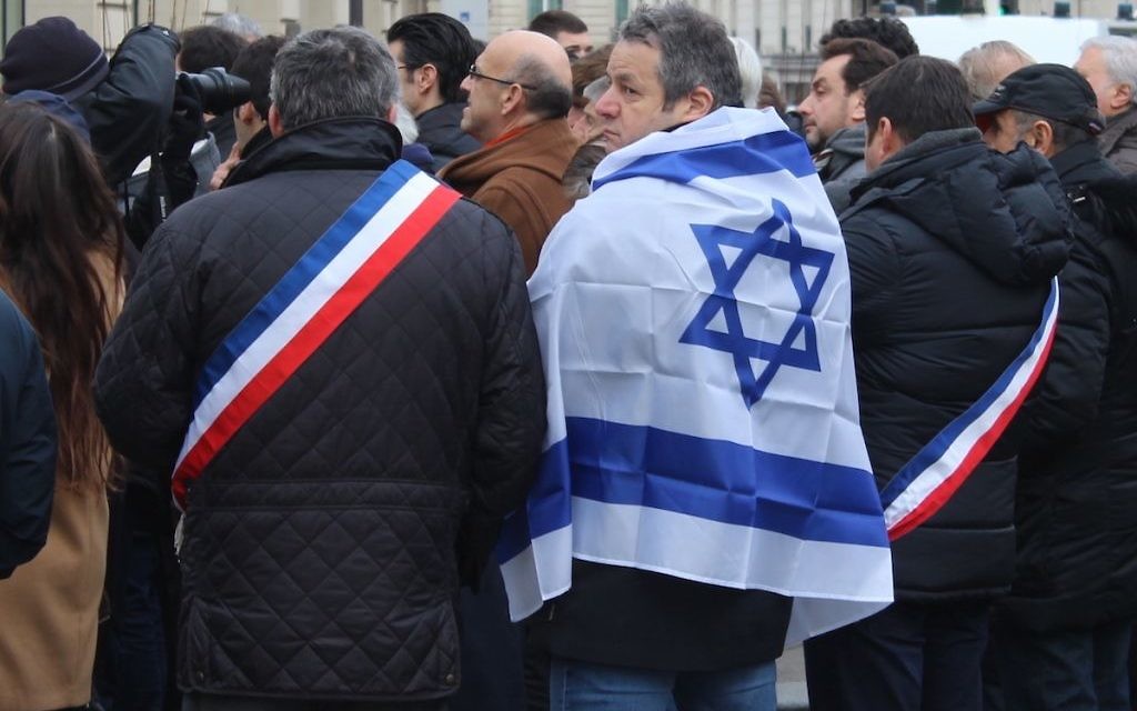 Des élus français et un manifestant, devant la scène de la manifestation contre la conférence de paix à Paris (Crédit : Glenn Cloarec/Times of Israël)