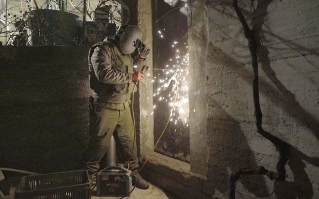 Un soldat israélien ferme un atelier soupçonné d'être utilisé par le Hamas pour fabriquer des armes, à Hébron, le 30 janvier 2017. (Crédit : unité des porte-paroles de l'armée israélienne) Un soldat israélien ferme un atelier soupçonné d'être utilisé par le Hamas pour fabriquer des armes, à Hébron, le 30 janvier 2017. (Crédit : unité des porte-paroles de l'armée israélienne)