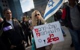 Des soutiens d'Elor Azaria, jugé coupable d'homicide, avec un panneau "terroriste = victime ?! soldat protecteur = assassin ?!" devant la cour militaire de la Kirya à Tel Aviv, le 4 janvier 2017. (Crédit : Miriam Alster/Flash90)