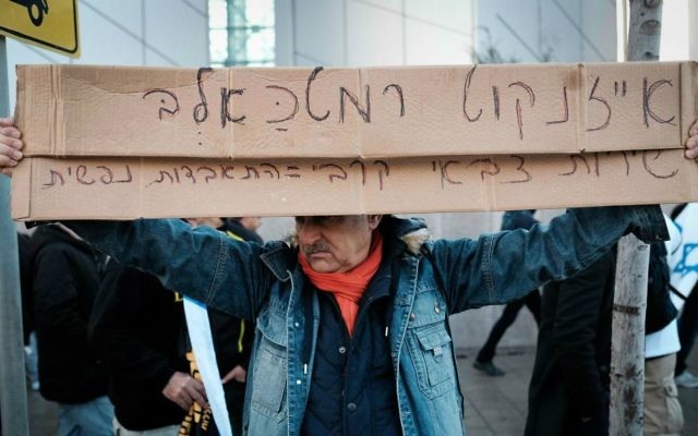 Manifestant contre le verdict de culpabilité d'Elor Azaria, devant le siège de la Kirya, à Tel Aviv, qui appelle Gadi Eizenkot, le chef d'Etat-major de Tsahal, un "chien", le 4 janvier 2017. (Crédit : Tomer Neuberg/Flash90) Manifestant contre le verdict de culpabilité d'Elor Azaria, devant le siège de la Kirya, à Tel Aviv, qui appelle Gadi Eizenkot, le chef d'Etat-major de Tsahal, un "chien", le 4 janvier 2017. (Crédit : Tomer Neuberg/Flash90)
