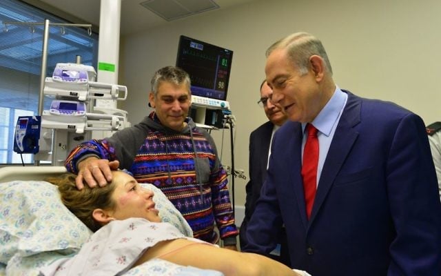 Le Premier ministre Benjamin Netanyahu au chevet d'une victime de l'attentat terroriste au camion bélier du 8 janvier à Jérusalem, qui a fait quatre morts et 16 blessés, le 9 janvier 2017. (Crédit : Kobi Gideon/GPO)