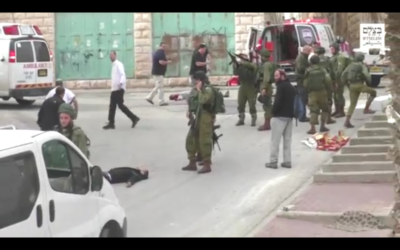 Un soldat israélien chargeant son arme avant de sembler tirer à la tête sur un assaillant palestinien au sol, apparemment désarmé, à la suite d'une attaque au couteau à Hébron, le 24 mars 2016. (Crédit : capture d'écran B'TSelem)