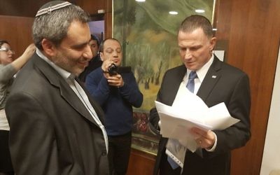 Yuli Edelstein, à droite, président de la Knesset, avec les 72 signatures de député demandant un vote sur la destitution du député arabe Basel Ghattas, remises par Zeev Elkin, à gauche, ministre du Likud, à la Knesset, le 16 janvier 2017. (Crédit : département des portes-paroles de la Knesset)