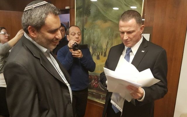 Yuli Edelstein, à droite, président de la Knesset, avec les 72 signatures de député demandant un vote sur la destitution du député arabe Basel Ghattas, remises par Zeev Elkin, à gauche, ministre du Likud, à la Knesset, le 16 janvier 2017. (Crédit : département des portes-paroles de la Knesset)