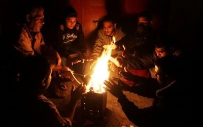 Des palestiniens se réchauffent autour d'un feu pour pallier le manque d'électricité, à Rafah, dans la bande de Gaza, le 1er décembre 2016. (Abed Rahim Khatib/Flash90)