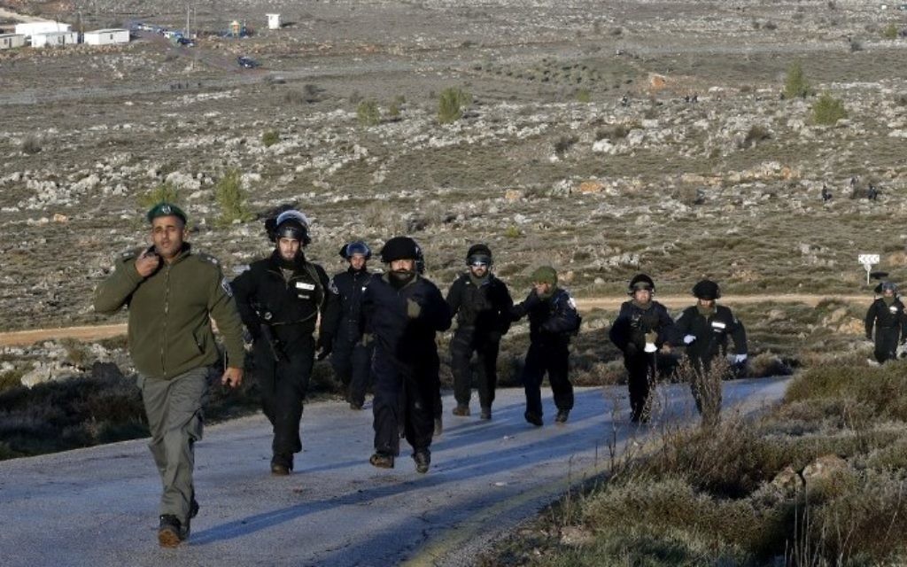 Les forces de sécurité israéliennes se rassemblent à l'avant-poste d'Amona, au nord est de Ramallah, en Cisjordanie, le 1er février 2017. (Crédit : Jack Guez/AFP)