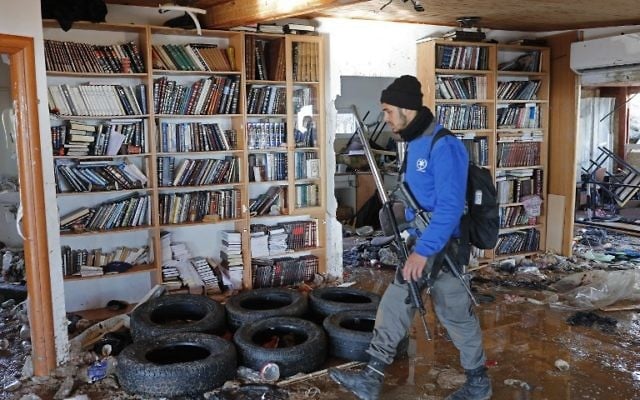 Un policier marchant à l'intérieur de la synagogue d'Amona où les jeunes se sont barricadés avant d'être expulsés le 2 février 2017 (Crédit : AFP PHOTO / Thomas COEX) Un policier marchant à l'intérieur de la synagogue d'Amona où les jeunes se sont barricadés avant d'être expulsés le 2 février 2017 (Crédit : AFP PHOTO / Thomas COEX)