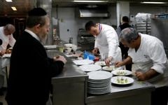 Lors de l'édition 2017, le chef français Laurent Delarbre (au centre) aide à préparer un menu casher, sous la supervision d'un rabbin (à gauche), lors de la semaine consacrée à la cuisine française, "So French, so Food au restaurant "La Vache sur le toit"", le 8 février 2017 à Jérusalem (Crédit : AFP PHOTO / THOMAS COEX)