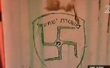 Un graffiti retrouvé sur la synagogue de l'avant-poste d'Amona, en Cisjordanie, représentant une croix gammée et les mots "police d'Ishmaël", une référence au fils d'Abraham qui serait l'ancêtre des Arabes d'aujourd'hui, le 2 février 2017. (Crédit : capture d'écran Deuxième chaîne)