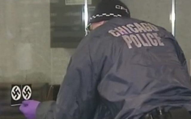 Un agent de police enlève un autocollant représentant une croix gammée sur la porte de la synagogue Loop de Chicago le 4 février 2017. La police estime qu'il s'agit d'un crime de haine. (Capture d'écran : NBC Chicago)