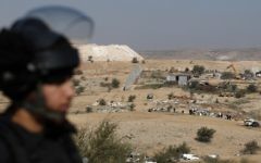 Un policier israélien en train de protéger les bulldozers qui détruisent des maisons dans le village bédouin d'Umm al-Hiran, dans le désert du Néguev, le 18 janvier 2017. (Crédit : Menahem Kahana/AFP)