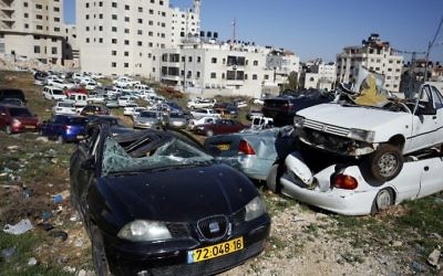 Epaves de voitures avec des plaques d'immatriculation israéliennes dans le village d'al-Ram, en Cisjordanie, le 6 mars 2017. (Crédit : Abbas Momani/AFP)