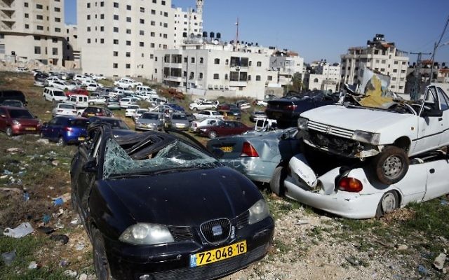 Epaves de voitures avec des plaques d'immatriculation israéliennes dans le village d'al-Ram, en Cisjordanie, le 6 mars 2017. (Crédit : Abbas Momani/AFP) Epaves de voitures avec des plaques d'immatriculation israéliennes dans le village d'al-Ram, en Cisjordanie, le 6 mars 2017. (Crédit : Abbas Momani/AFP)