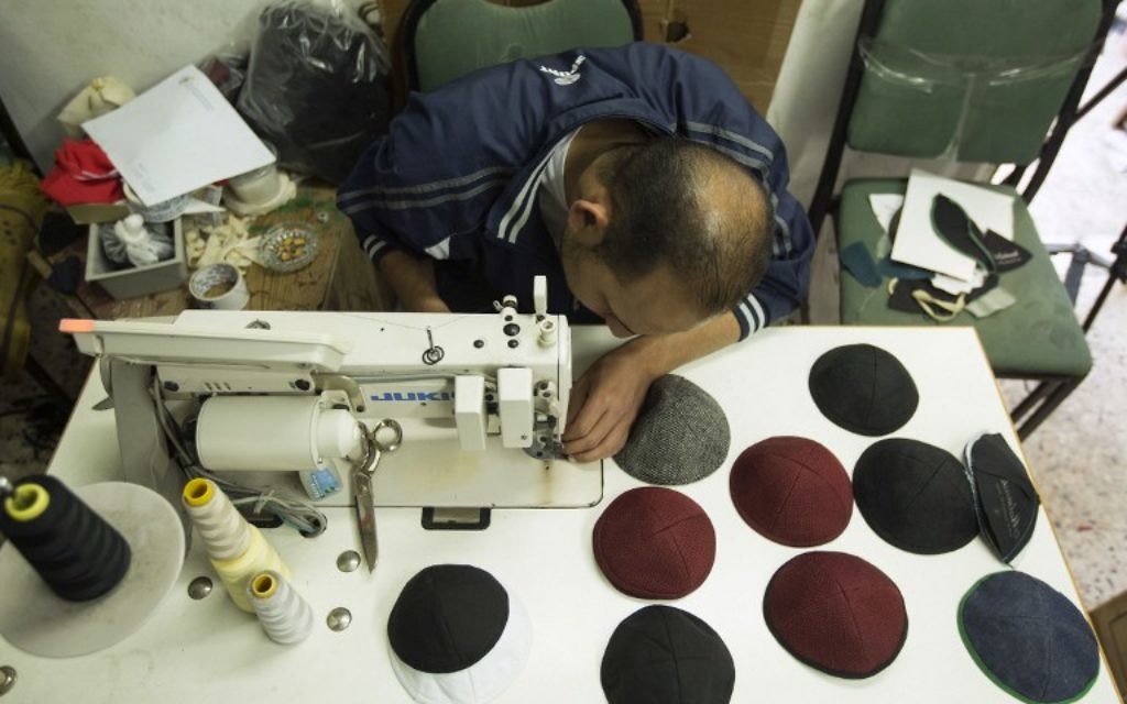 Un Palestinien travaillant dans une usine textile de Gaza fabriquant des kippas, le 8 mars 2017 (Crédit : AFP / Mahmud Hams)