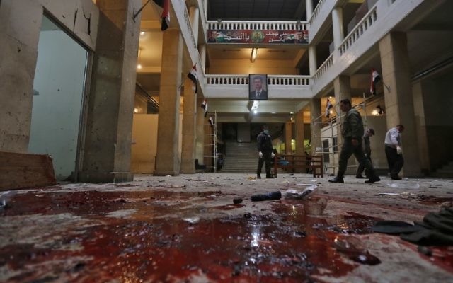 Les forces de sécurité syriennes sur les lieux d'un attentat suicide dans l'ancien palais de justice de Damas, en Syrie, le 15 mars 2017. (Crédit : Louai Beshara/AFP)