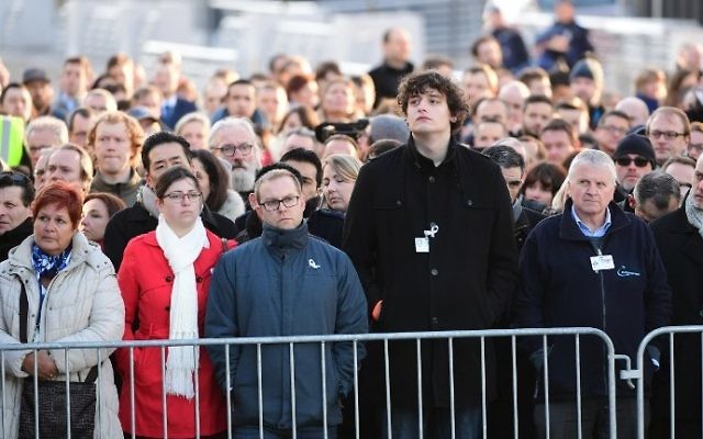 Les employés de l'aéroport international de Bruxelles pendant la cérémonie de commémoration du premier anniversaire des attentats, le 22 mars 2017. (Crédit : Emmanuel Dunand/AFP)