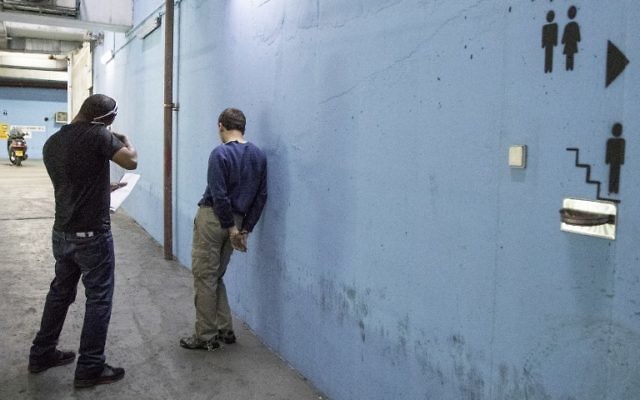 L'adolescent juif israélo-américain qui a été accusé d'avoir lancé des dizaines d'alertes à la bombe antisémites aux Etats-Unis et ailleurs, escorté par des gardes alors qu'il quitte le tribunal israélien de Rishon Lezion, le 23 mars 2017. (Crédit : Jack Guez/AFP) L'adolescent juif israélo-américain qui a été accusé d'avoir lancé des dizaines d'alertes à la bombe antisémites aux Etats-Unis et ailleurs, escorté par des gardes alors qu'il quitte le tribunal israélien de Rishon Lezion, le 23 mars 2017. (Crédit : Jack Guez/AFP)