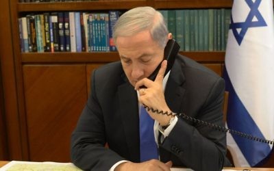 Le Premier ministre Benjamin Netanyahu au téléphone dans son bureau, à Jérusalem, le 28 avril 2015. Illustration. (Crédit : Amos Ben Gershon/GPO)