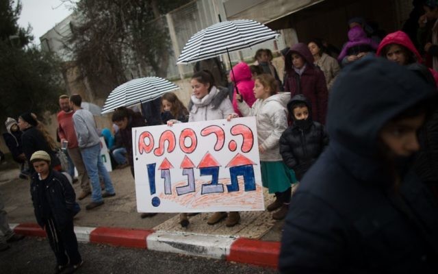 Manifestation des évacués de l’avant-poste illégal d’Amona devant le bureau du Premier ministre à Jérusalem, brandissant une pancarte disant : « Vous avez détruit nos foyers », le 12 février 2017. (Crédit : Yonatan Sindel/Flash90) Manifestation des évacués de l’avant-poste illégal d’Amona devant le bureau du Premier ministre à Jérusalem, brandissant une pancarte disant : « Vous avez détruit nos foyers », le 12 février 2017. (Crédit : Yonatan Sindel/Flash90)
