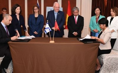 Le président Reuven Rivlin (centre) supervise la signature d'un accord de collaboration en matière d'éducation, au Vietnam. (Crédit : Koby Gideon /GPO)