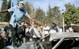 Un Palestinien célébrant sur le toit d'une voiture brûlée le lynchage de deux réservistes israéliens, à Ramallah, le 12 octobre 2000. (Crédit : Flash90)