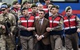 Des personnes, principalement des soldats turcs, accusées d'avoir tenté d'assassiner le président Erdogan pendant une tentative de coup d'état en juillet, sont escortées par les forces de sécurité pour être présentées au tribunal de Mugla, le 20 février 2017. (Crédit : Bulent Kilic/AFP)