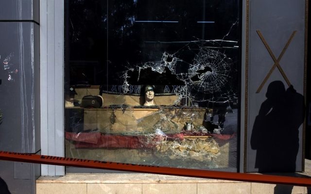 La vitrine brisée du siège du parti néo-nazi Aube dorée, à Athènes, le 31 mars 2017. (Crédit : Angelos Tzortzinis/AFP) La vitrine brisée du siège du parti néo-nazi Aube dorée, à Athènes, le 31 mars 2017. (Crédit : Angelos Tzortzinis/AFP)