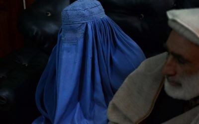 Cette photographie prise le 16 janvier 2017 montre une jeune femme afghane Nadia, 22 ans, qui tente de divorcer de son mari, lors d'un entretien, en présence de son père, avec un journaliste de l'AFP au bureau de son avocat à Jalalabad, Afghanistan (Crédit: AFP PHOTO / NOORULLAH SHIRZADA)