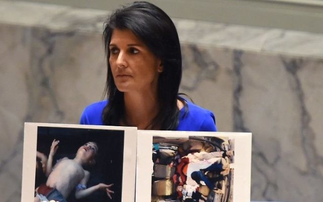 Nikki Haley, l'ambassadrice américaine aux Nations Unies, montre des photos des victimes de l'attaque meurtrière chimique présumée qui a tué des civils, et notamment des enfants, en Syrie, lors d'une réunion d'urgence du Conseil de sécurité, le 5 avril 2017. (Crédit : Timothy A. Clary/AFP)