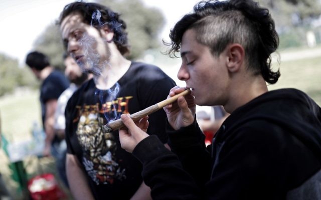 Un Israélien fume un joint à Jérusalem le 20 avril 2017 lors d'un rassemblement au jardin des roses, en Israël (Crédit : AFP PHOTO / THOMAS COEX)
