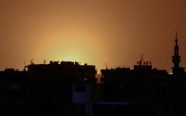 Photographie prise depuis Douma, ville tenue par les rebelles, de la zone de l'aéroport international de Damas après une explosion, attribuée à une frappe israélienne, le 27 avril 2017. (Crédit : Sameer Al-Doumy/AFP)