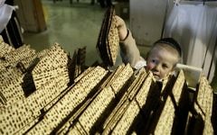 Un enfant entouré de matzas. Illustration. (Crédit : Abir Sultan/Flash90)