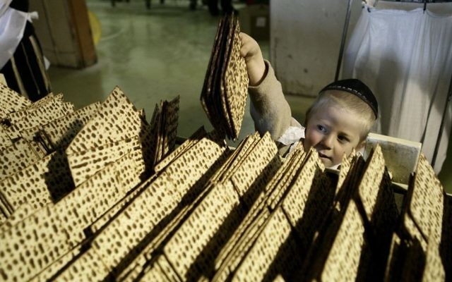 Un enfant entouré de matzas. Illustration. (Crédit : Abir Sultan/Flash90)